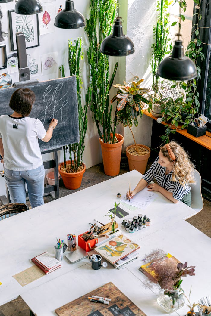 Adult students engage in an artistic workshop, focusing on blackboard illustration and sketching indoors.